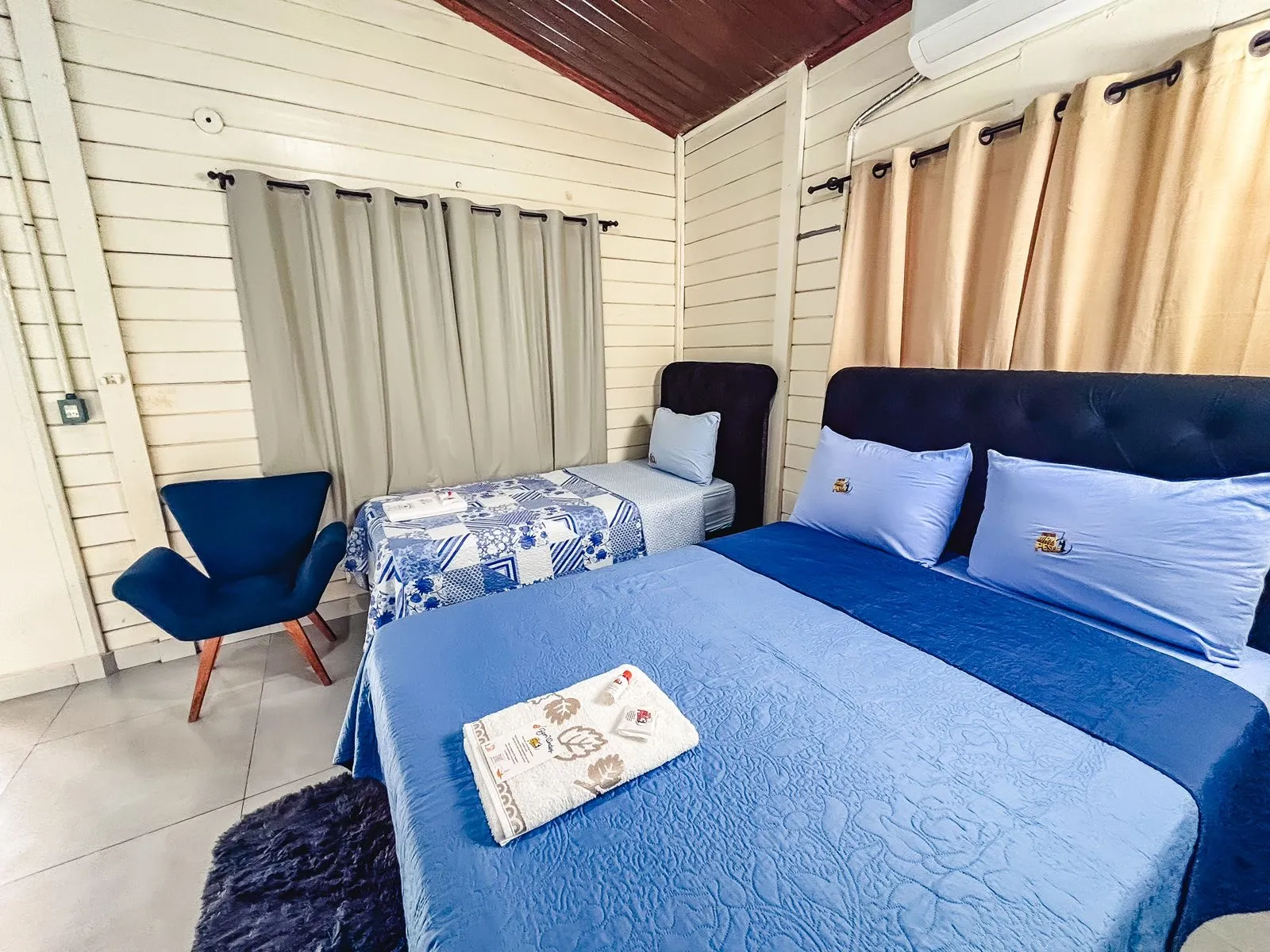 Quarto com cama de casal, cama de solteiro e ar-condicionado